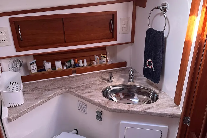 Slide: The Image of 2017 Sabre 42 Salon Express bathroom with sink, wooden cabinets, and toiletries. - 14