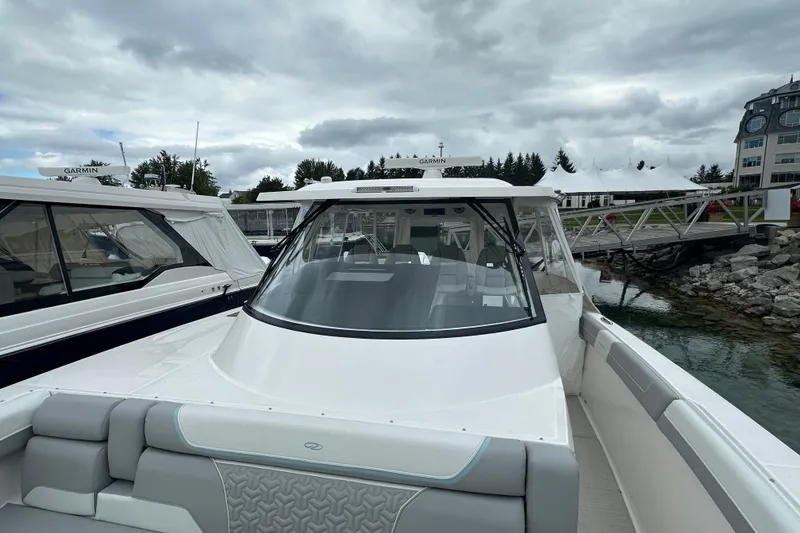 Slide: The Image of 2026 Regal 38 SAV boat docked, showcasing sleek design and spacious seating under cloudy skies. - 31