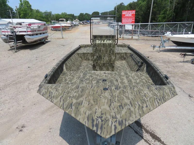Slide: The Image of 2024 SeaArk Shadow 19v CC boat with camouflage design, parked on gravel lot. - 1
