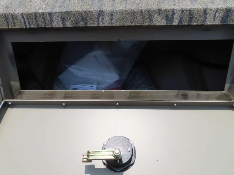 Slide: The Image of 2024 SeaArk Shadow 19v CC boat compartment with secure latch and camouflage design. - 10