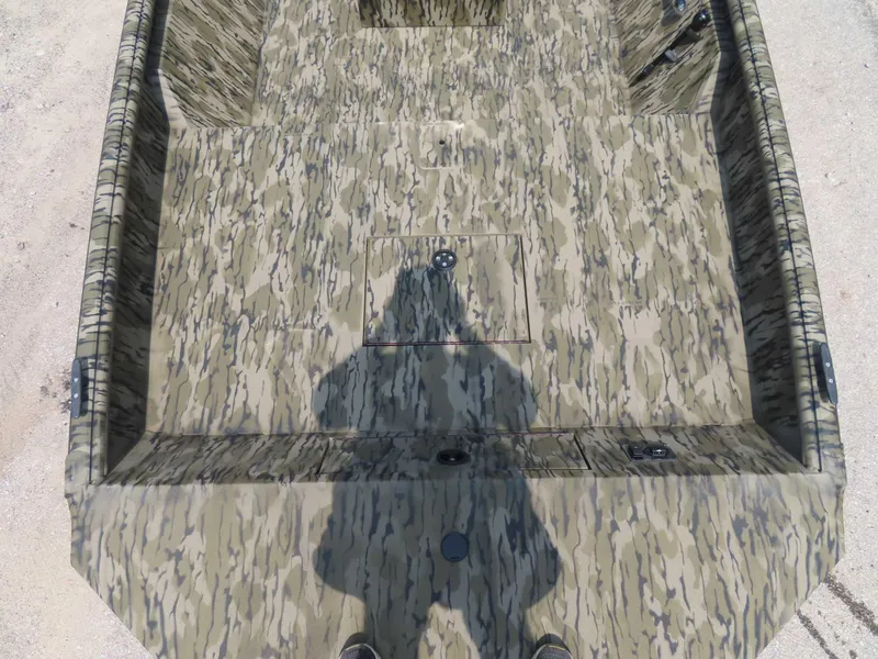 Slide: The Image of 2024 SeaArk Shadow 19v CC boat interior with camouflage pattern and shadow. - 12