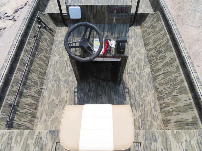 Slide: The Image of 2024 SeaArk Shadow 19v CC boat interior with camouflage design and steering console. - 4