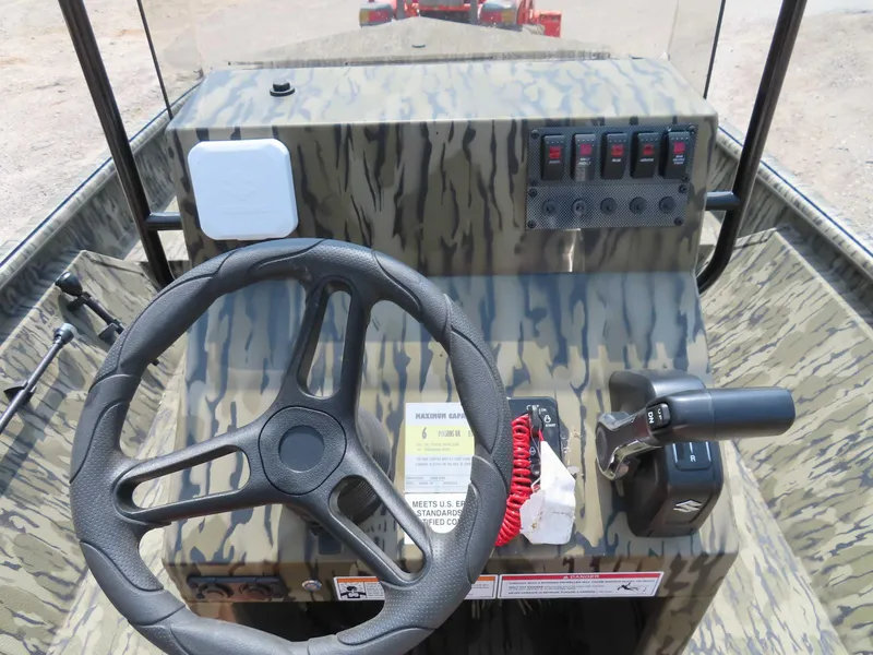 Slide: The Image of 2024 SeaArk Shadow 19v CC boat console with steering wheel and controls. - 7