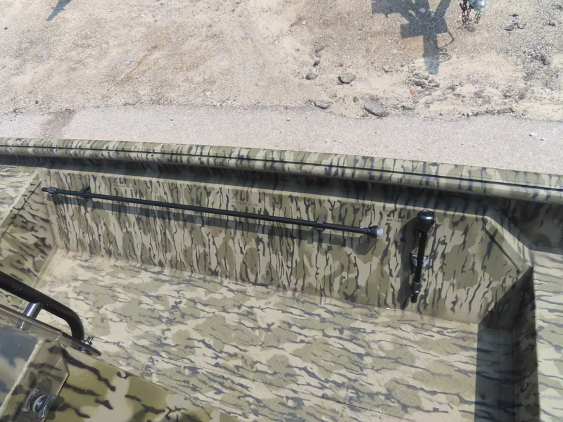 Slide: The Image of 2024 SeaArk Shadow 19v CC boat interior with camouflage design, featuring rod holders. - 8