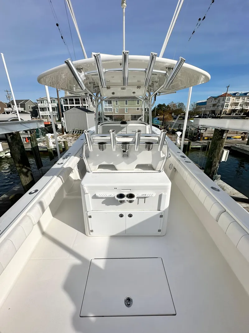 Slide: The Image of 2015 Regulator 34 boat with center console and rod holders, docked at a marina. - 11