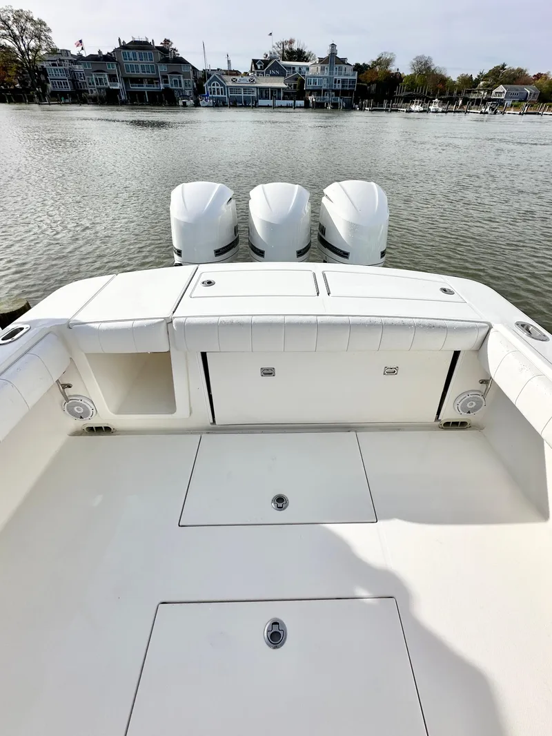 Slide: The Image of 2015 Regulator 34 boat with triple engines, docked near waterfront homes. - 12