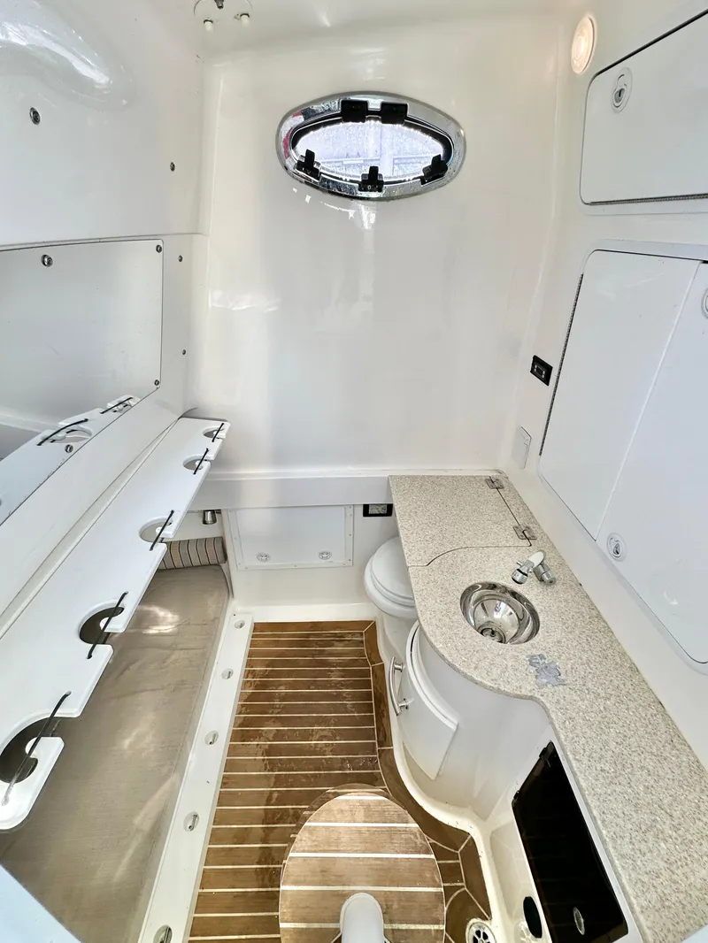 Slide: The Image of 2015 Regulator 34 boat interior with sink, wooden flooring, and storage compartments. - 15
