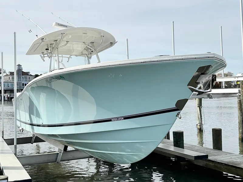 Slide: The Image of 2015 Regulator 34 boat docked, showcasing sleek design and light blue hull. - 2