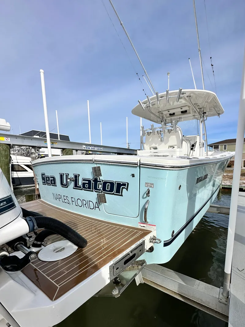 Slide: The Image of 2015 Regulator 34 boat docked, light blue hull, "Sea U-Lator" name visible. - 6