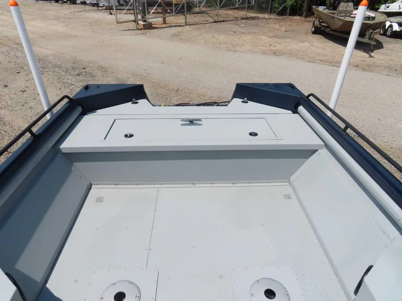 Slide: The Image of 2024 SeaArk Pro Guide 2672 boat deck with storage compartments and rod holders. - 12