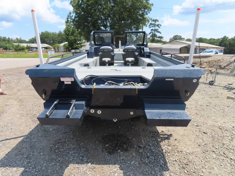 Slide: The Image of 2024 SeaArk Pro Guide 2672 boat, rear view, parked on gravel, clear sky background. - 15