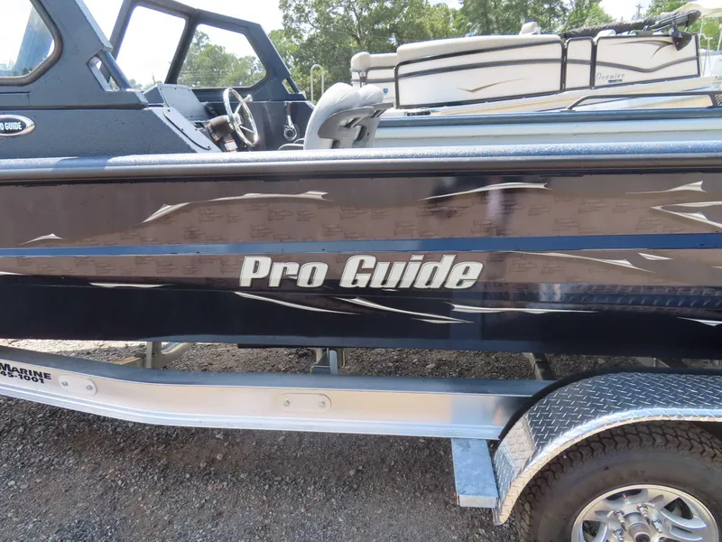 Slide: The Image of 2024 SeaArk Pro Guide 2672 boat side view with sleek design and logo. - 19