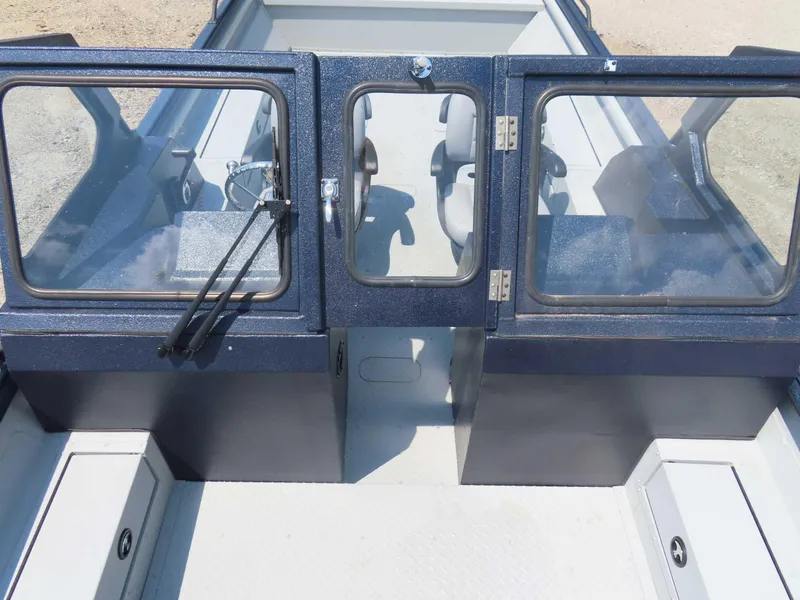 Slide: The Image of 2024 SeaArk Pro Guide 2672 boat interior with glass doors and seating. - 2