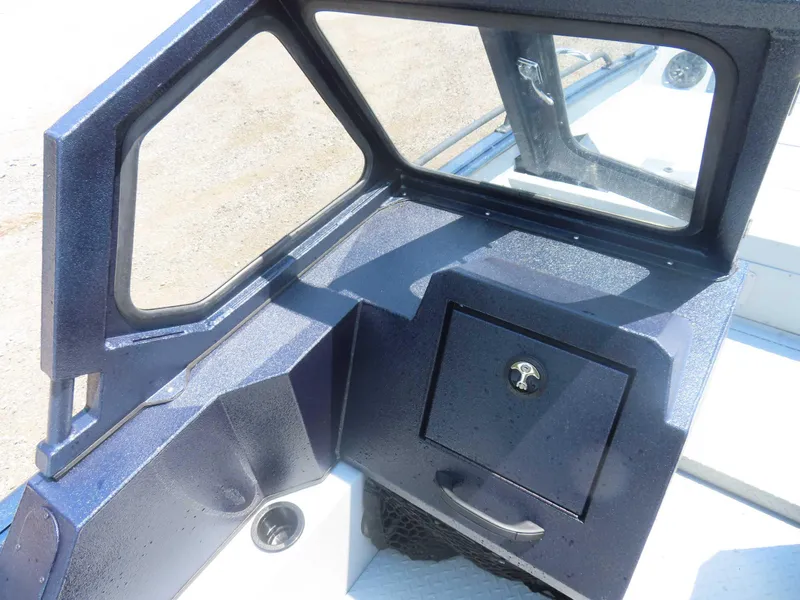 Slide: The Image of 2024 SeaArk Pro Guide 2672 boat interior with storage compartment and window. - 5
