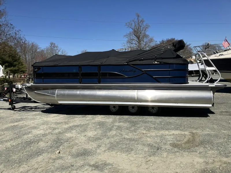 Slide: The Image of 2025 Bentley Pontoons 223 Cruise pontoon boat with cover, parked on a trailer outdoors. - 3
