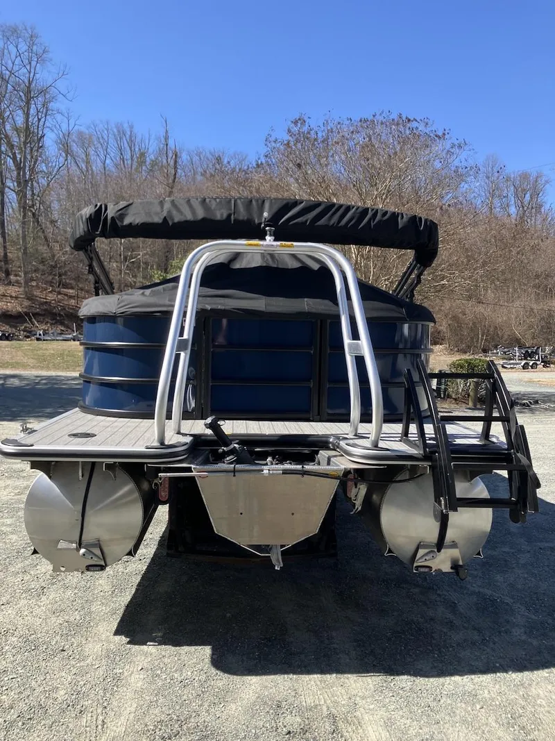 Slide: The Image of 2025 Bentley Pontoons 223 Cruise, rear view, parked on gravel, with trees in the background. - 4
