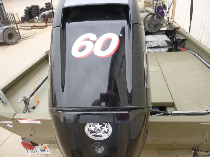 Slide: The Image of 2011 Lowe Roughneck R1760SC boat with a 60 HP outboard motor, parked outdoors. - 11