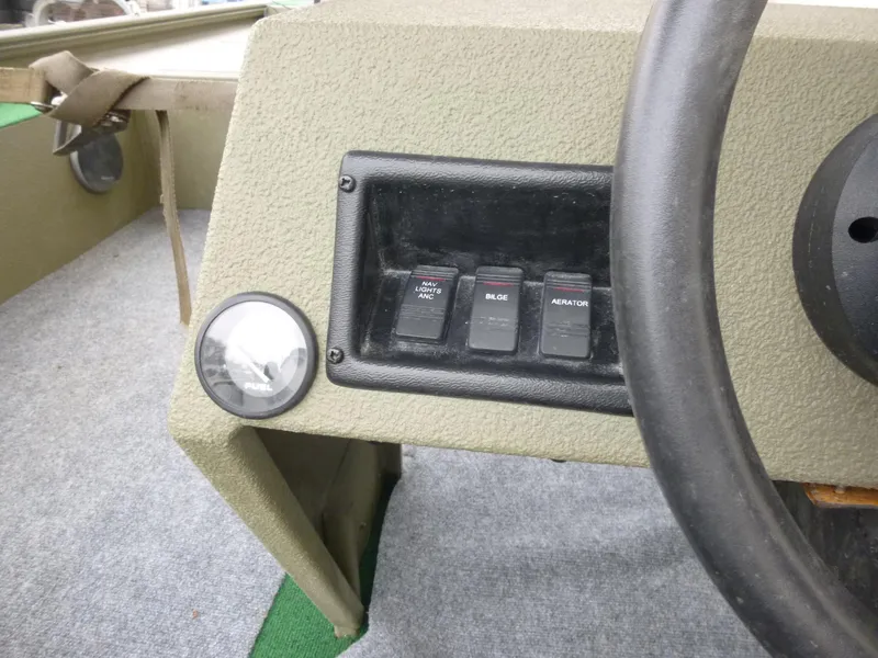 Slide: The Image of Control panel of a 2011 Lowe Roughneck R1760SC boat with switches and steering wheel. - 16