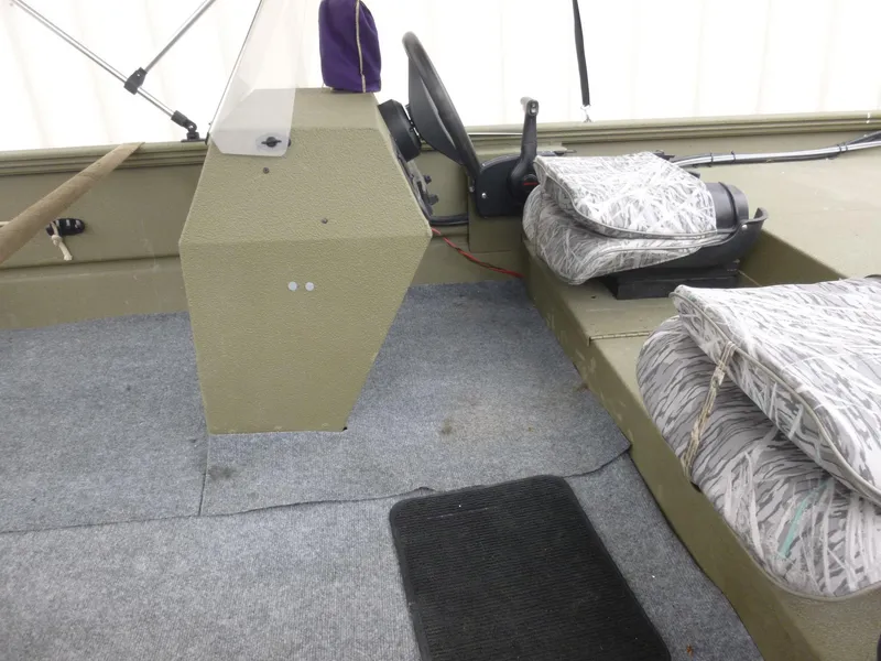 Slide: The Image of 2011 Lowe Roughneck R1760SC boat interior with console, seats, and carpeted flooring. - 19