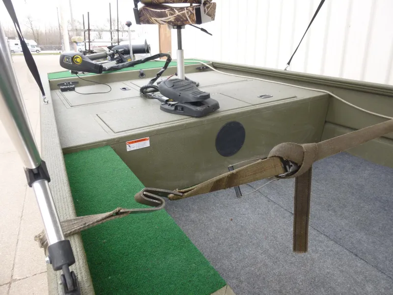 Slide: The Image of 2011 Lowe Roughneck R1760SC boat interior with green and gray carpet, featuring fishing equipment. - 20