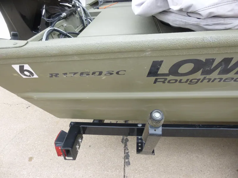 Slide: The Image of 2011 Lowe Roughneck R1760SC boat on trailer, side view with model details visible. - 28