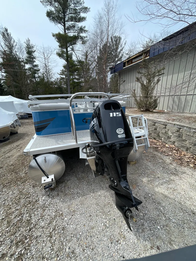 Slide: The Image of 2025 Tahoe 21 Sport 85 pontoon boat with powerful outboard motor, parked outdoors. - 10