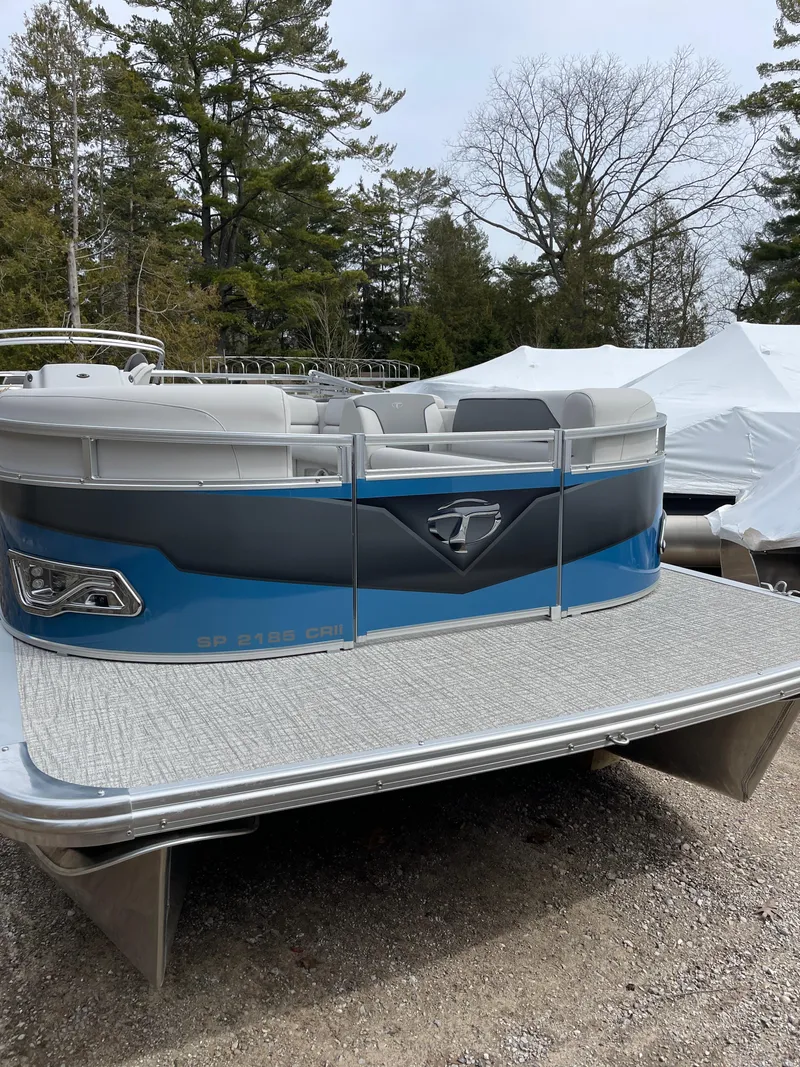 Slide: The Image of 2025 Tahoe 21 Sport 85 pontoon boat, parked outdoors with trees in the background. - 4