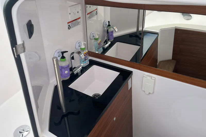 Slide: The Image of 2022 Axopar 28 Cabin Brabus Package bathroom with modern sink and mirror. - 13