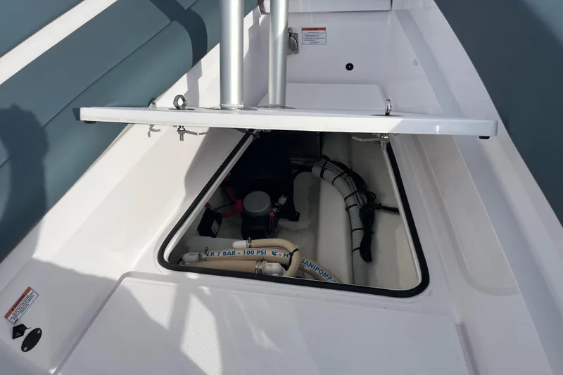 Slide: The Image of 2022 Axopar 28 Cabin Brabus Package boat storage compartment with visible hoses and equipment. - 22