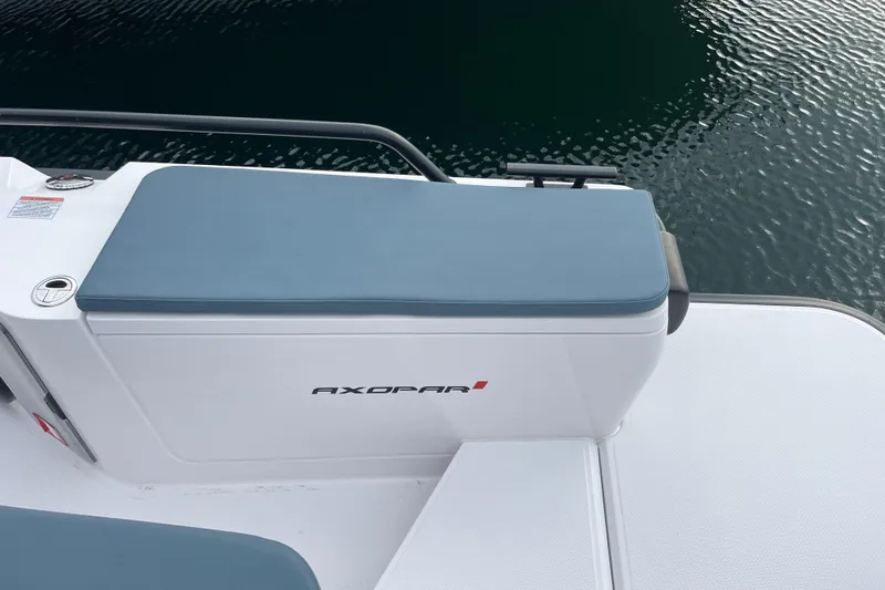 Slide: The Image of 2022 Axopar 28 Cabin Brabus Package, sleek design, white and blue seating, docked by water. - 24
