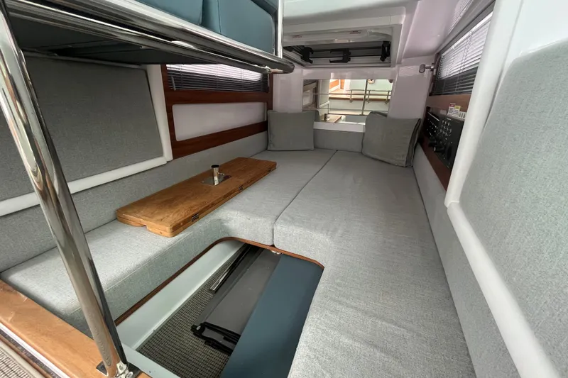 Slide: The Image of 2022 Axopar 28 Cabin interior with Brabus Package, featuring modern gray seating and wooden accents. - 26