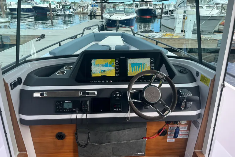 Slide: The Image of 2022 Axopar 28 Cabin Brabus Package dashboard with dual screens at marina. - 4