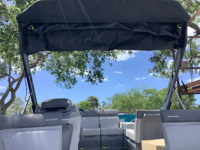 Slide: The Image of 2024 Sea-Doo Switch Cruise 18 pontoon boat with canopy, outdoor setting. - 10