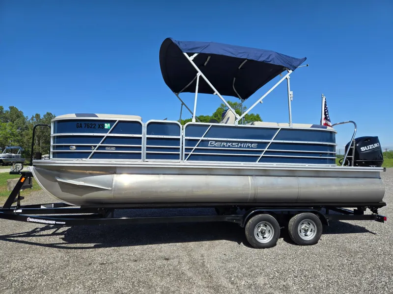 Slide: The Image of 2021 Berkshire 22 RFX LE-Series pontoon boat on trailer, blue canopy, sunny day. - 0