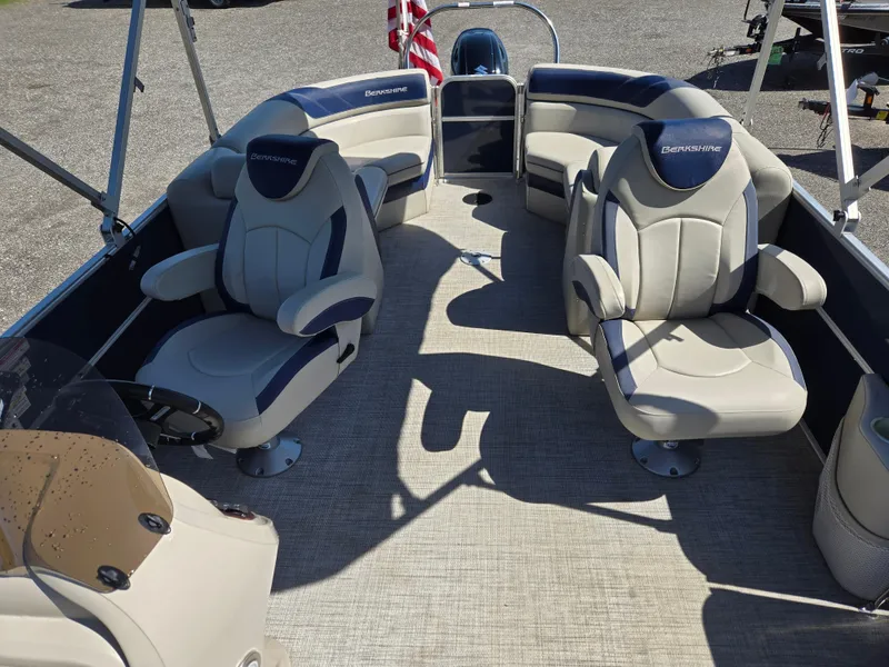 Slide: The Image of 2021 Berkshire 22 RFX LE-Series pontoon boat interior with plush seating and steering console. - 16