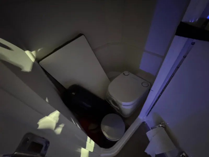 Slide: The Image of Compact bathroom in 2019 Sea Ray SPX 230 boat, featuring a toilet and storage space. - 11