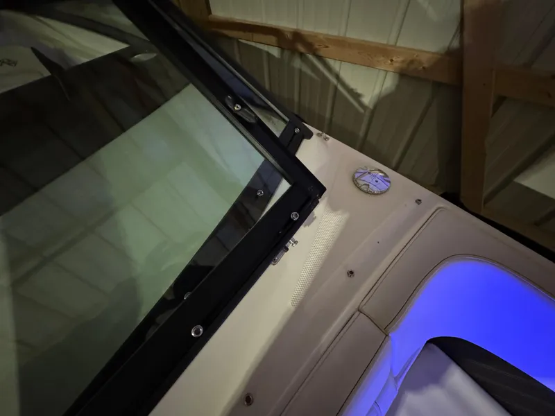 Slide: The Image of 2019 Sea Ray SPX 230 boat interior with windshield and blue ambient lighting. - 13