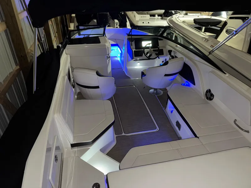 Slide: The Image of 2019 Sea Ray SPX 230 boat interior with modern seating and blue ambient lighting. - 2