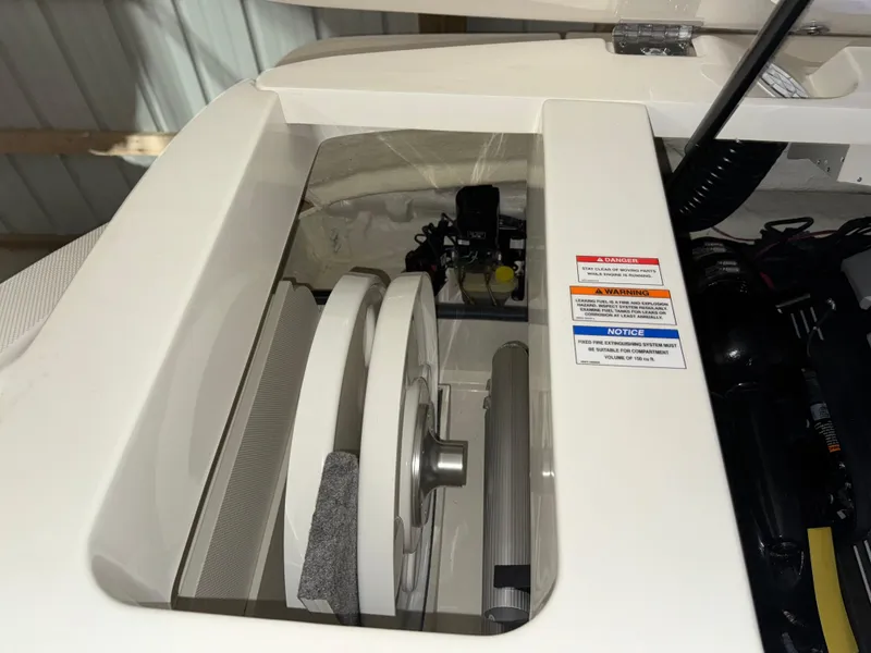 Slide: The Image of Engine compartment of a 2019 Sea Ray SPX 230 boat, showing mechanical components and safety labels. - 21