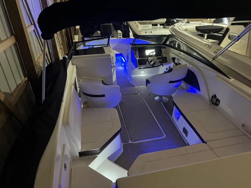 Slide: The Image of 2019 Sea Ray SPX 230 boat interior with blue ambient lighting and white seating. - 3
