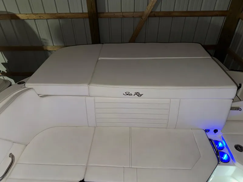 Slide: The Image of 2019 Sea Ray SPX 230 boat interior with white seating and blue accent lighting. - 4
