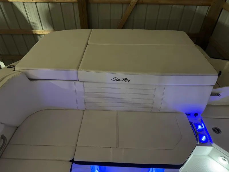 Slide: The Image of 2019 Sea Ray SPX 230 boat interior with beige seating and blue LED lighting. - 5