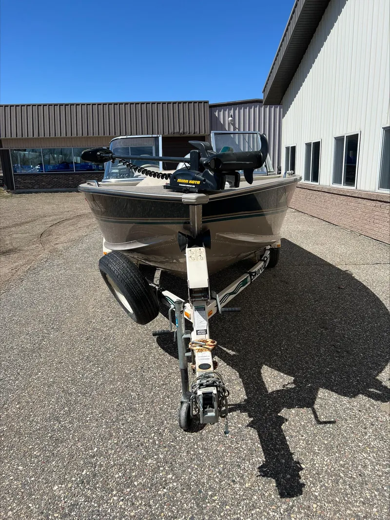 Slide: The Image of 2001 Alumacraft Trophy 185 boat on trailer, parked outside a building. - 11