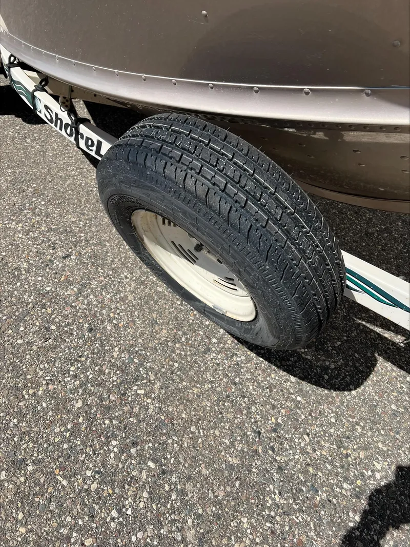 Slide: The Image of Trailer tire of a 2001 Alumacraft Trophy 185 boat on asphalt. - 8