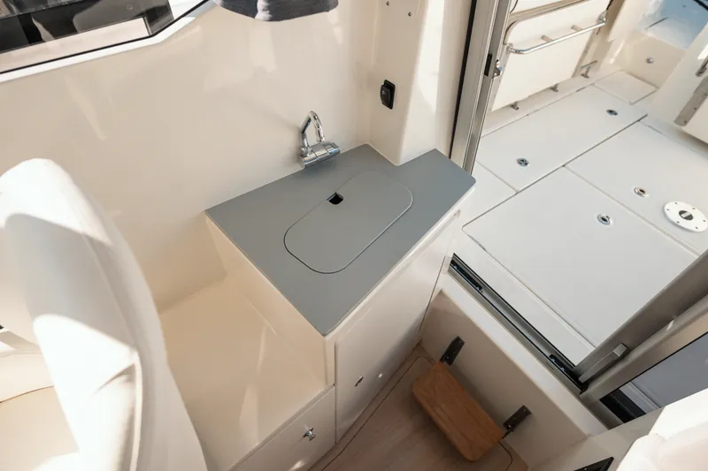 Slide: The Image of 2024 Bayliner Trophy T25 Pilothouse interior with compact sink and modern design. - 11
