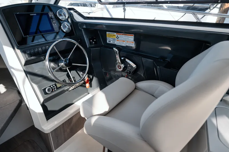 Slide: The Image of 2024 Bayliner Trophy T25 Pilothouse helm with steering wheel and controls. - 16