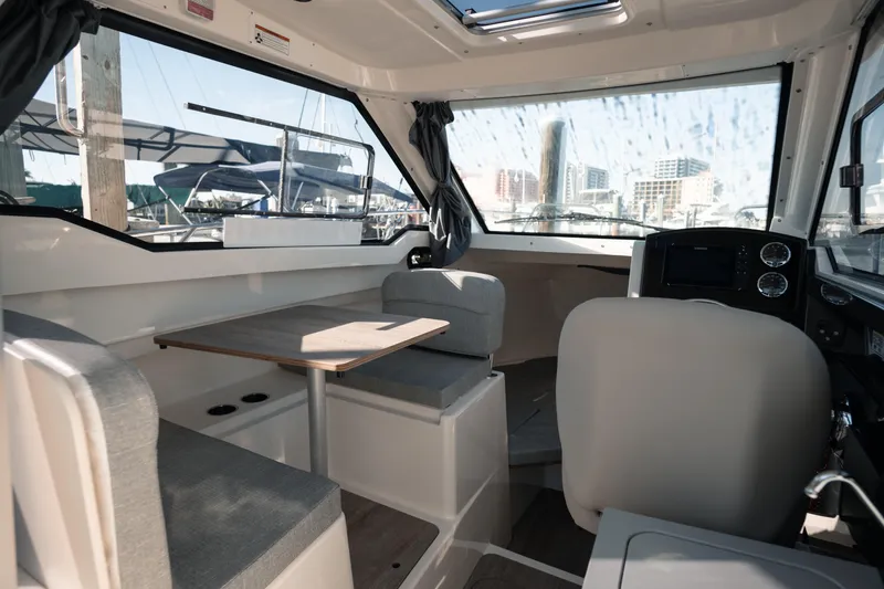 Slide: The Image of 2024 Bayliner Trophy T25 Pilothouse interior with seating and navigation area. - 17