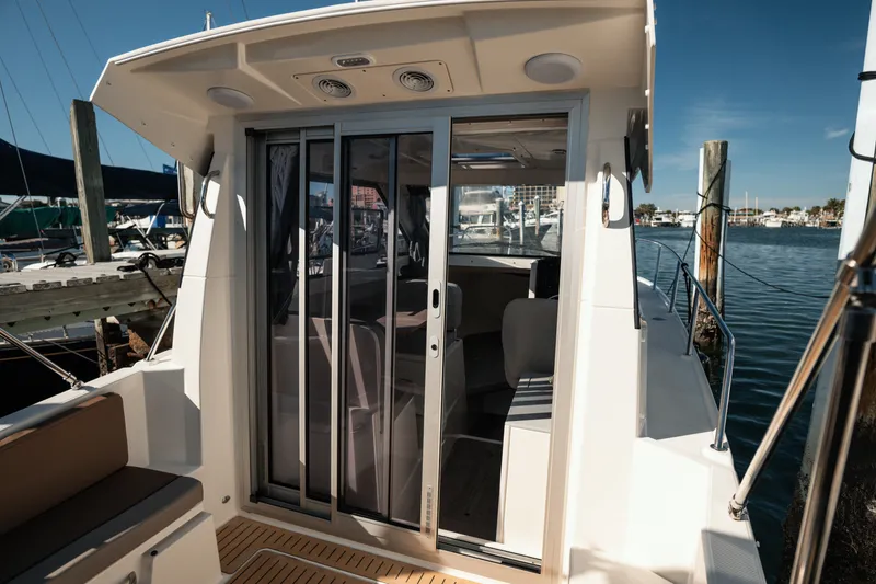 Slide: The Image of 2024 Bayliner Trophy T25 Pilothouse boat interior with sliding glass doors at marina. - 18