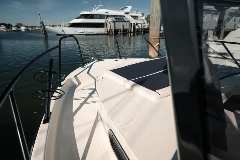 Slide: The Image of 2024 Bayliner Trophy T25 Pilothouse boat docked in a marina, with a yacht in the background. - 20