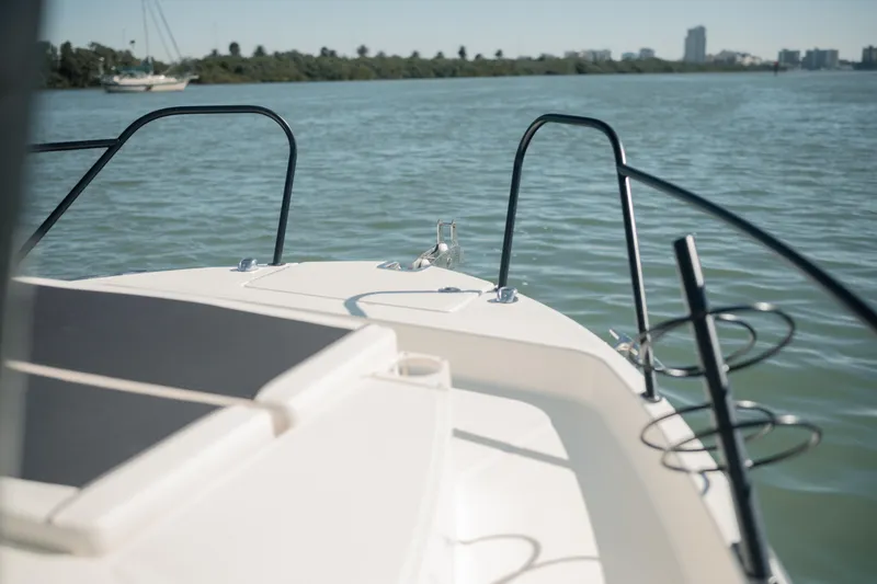 Slide: The Image of 2024 Bayliner Trophy T25 Pilothouse boat on calm water, scenic background. - 24